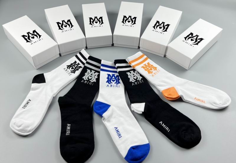 Various pairs of socks with visible branding on a gray background